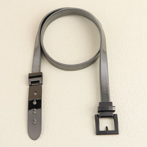 Detail view of black elastic skinny waist belt with square metal buckle and four holes