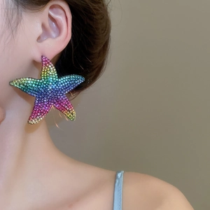 Macro detail of starfish earrings with vibrant rainbow crystal pavé on a model