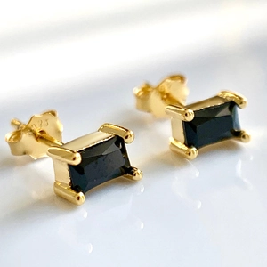 Macro shot of 925 silver hallmark on gold-plated stud earring with black square zircon