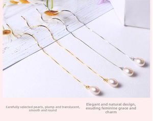 Detail of elegant gold and silver wavy thread earrings with drop pearls on wood