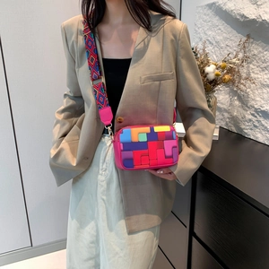 Colorful geometric patchwork crossbody bag with wide strap on a female model