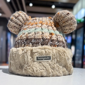 Close-up of winter knit hat featuring cute plush ears and textured mixed color yarn weaving
