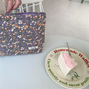 Vue détaillée de la trousse en velours côtelé violet à fleurs avec fermeture éclair