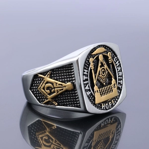 Detail of Masonic ring showing FAITH HOPE CHARITY engravings and golden relief emblem