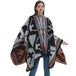 Detail shot of heavy jacquard knit poncho with Aztec geometric pattern and tassel fringe edges