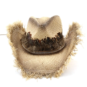 Detail of western raffia cowboy hat with feathered band and frayed fringe brim design