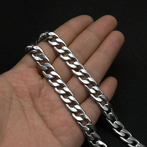 Close-up of a heavy silver stainless steel Cuban link chain held in hand