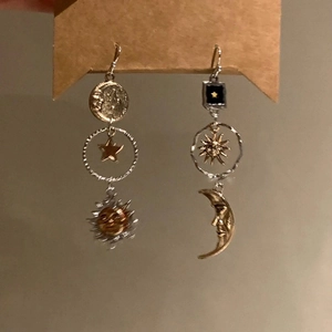 Retro sunflower earrings with asymmetrical sun and moon charms on a brown card
