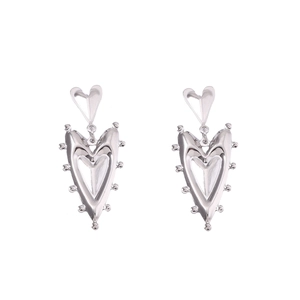 Macro view of silver heart drop earrings featuring textured beaded edges and metallic luster