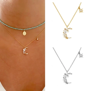 Detailed view of crescent moon pendants with zircons in gold and silver plating