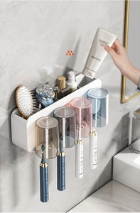 Wall-mounted bathroom organizer with four colorful cups and electric toothbrush holders