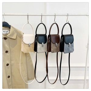 Detailed row of four minimalist small square crossbody bags in various neutral colors