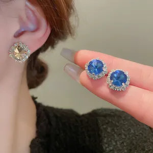 Luxuriöse Halo-Ohrstecker mit funkelnden blauen und klaren Strasssteinen in geometrischem Design