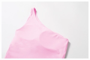 Detailed flat lay of pink one-shoulder yoga vest featuring built-in padding and soft fabric