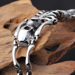 Macro shot of silver stainless steel skull bone bracelet on weathered wood in gothic style