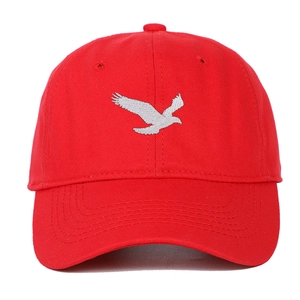 Détail de la broderie d'oiseau sur une casquette de baseball en coton rouge avec visière