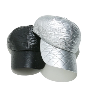 Detail of quilted baseball caps in metallic silver and classic black with diamond stitching