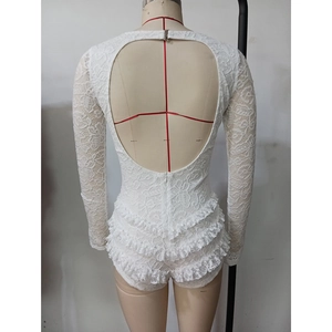 Détail du combishort en dentelle blanche avec manches longues et jupe à plusieurs niveaux