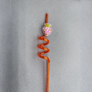 Detail of orange spiral plastic straw featuring a pink glitter carrot ornament decoration