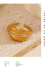 Macro detail of retro golden lip shaped ring with vertical ribbed texture on stone background