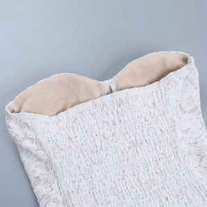 Detail of white floral lace embroidery with beige lining and elastic smocked waist