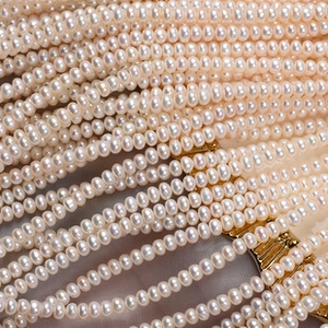 Macro shot of 4mm natural freshwater pearls with golden metal base detailing