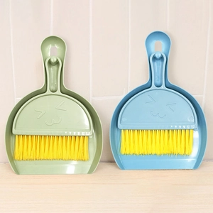Detail view of mini desktop cleaning set with smiley face broom and dustpan in pastel colors