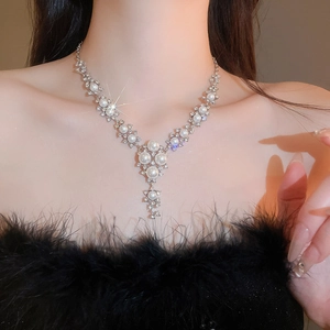 Elegant Y-shaped pearl necklace set featuring rhinestone flower charms worn by a model