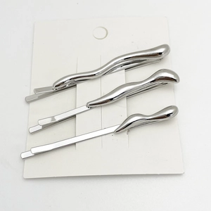 Three-piece silver alloy hair clips set with fluid wave design on white card