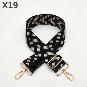 Detail of herringbone weave strap in black and beige with gold metal buckle
