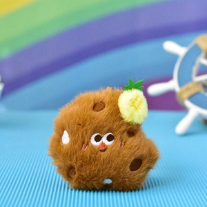 Close-up of a cute brown plush cookie pendant with embroidered eyes and pineapple detail