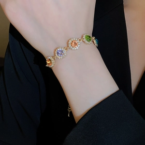 Gros plan détaillé d'un bracelet en pierres colorées porté sur une manche de costume noir
