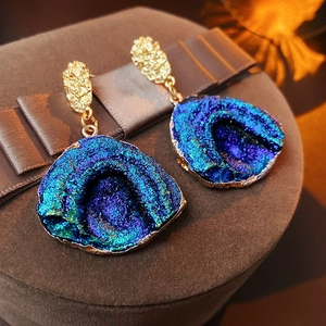 Macro detail of irregular blue purple druzy earrings with gold textured finish