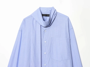 Detail of light blue shirt featuring bow-tie neck scarf and clear cotton texture