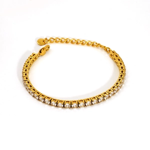 Détail d'un bracelet de tennis doré avec oxydes de zirconium ronds et fermoir mousqueton