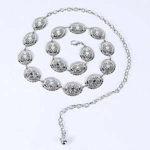 Detail showing silver metal waist chain with engraved oval discs and adjustable lobster clasp