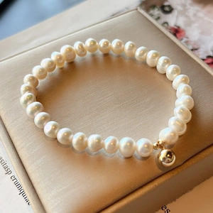 Detail of natural freshwater pearl bracelet with a 14K gold-filled bead on jewelry box