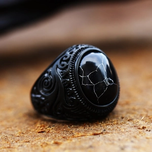 Macro di anello vintage nero con pietra marmorizzata e dettagli in rilievo barocco