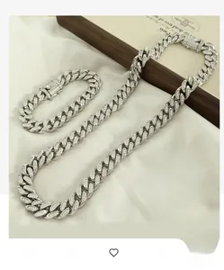 Close-up of iced out silver Cuban link necklace and bracelet set on silk background