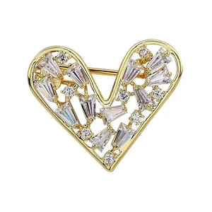 Minimalist heart-shaped gold brooch with crystal rhinestones on a white background