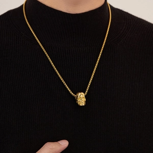 Men's vintage hip-hop skull pendant necklace in gold finish worn on black background