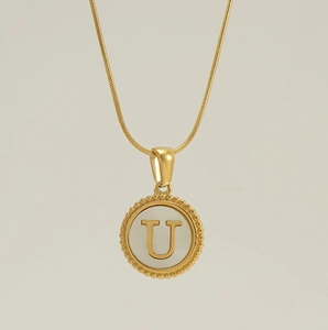 Detail of 18K gold-plated necklace with a shell letter U pendant and beaded edge decor