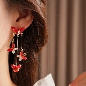 Gros plan de boucles d'oreilles papillon dorées à pampilles en cristal sur un mannequin