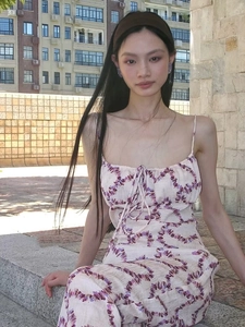 Close-up of elegant purple floral print dress with thin straps on a city terrace