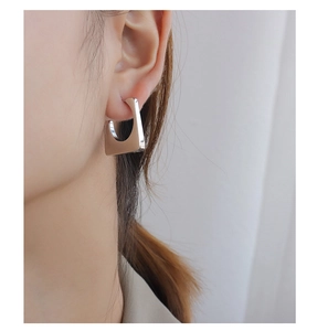 Minimalist geometric trapezoid earrings in silver finish worn by a female model
