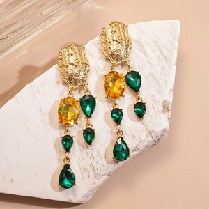 Detail of vintage bohemian drop earrings with green and yellow crystals on stone base