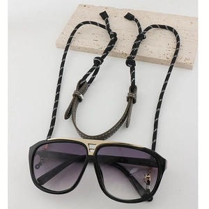 Detail of aviator sunglasses with black and white woven adjustable anti-lost lanyard cord