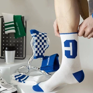 White crew socks with blue contrast toe and heel featuring a knitted letter T design