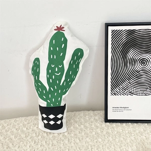 Detailed close-up of a cactus shaped plush pillow with artistic hand-painted style pattern