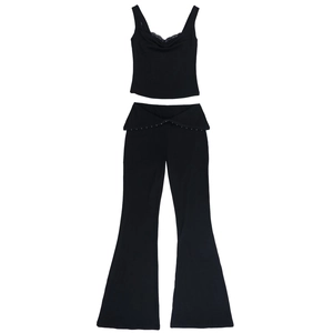 Dettaglio del set nero due pezzi con top in pizzo e pantaloni a zampa a vita a V
